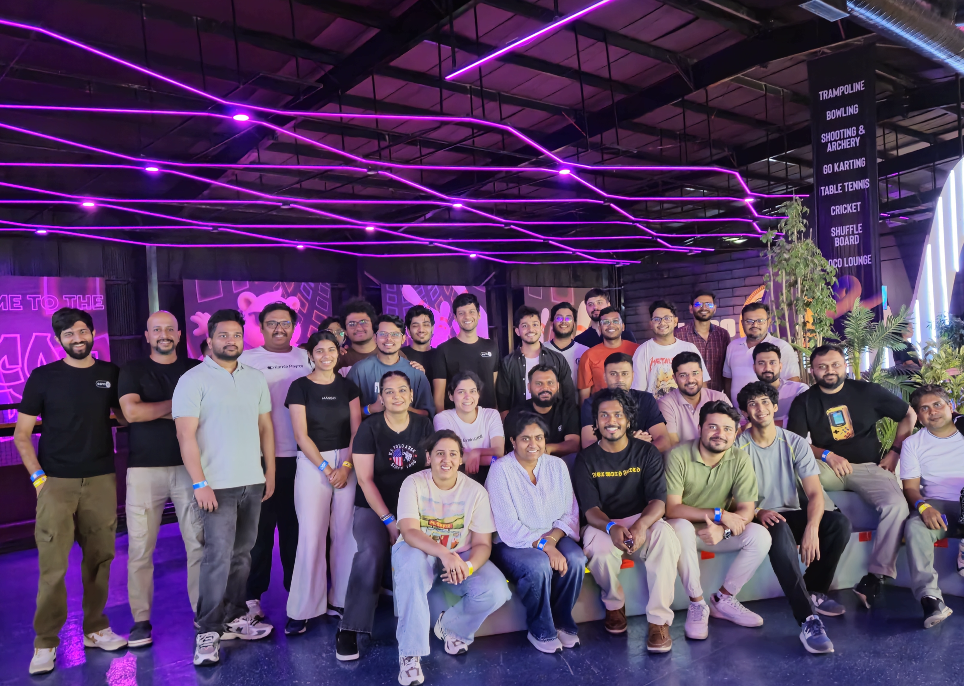 EarnIn India team posing together under purple neon lights at a team outing