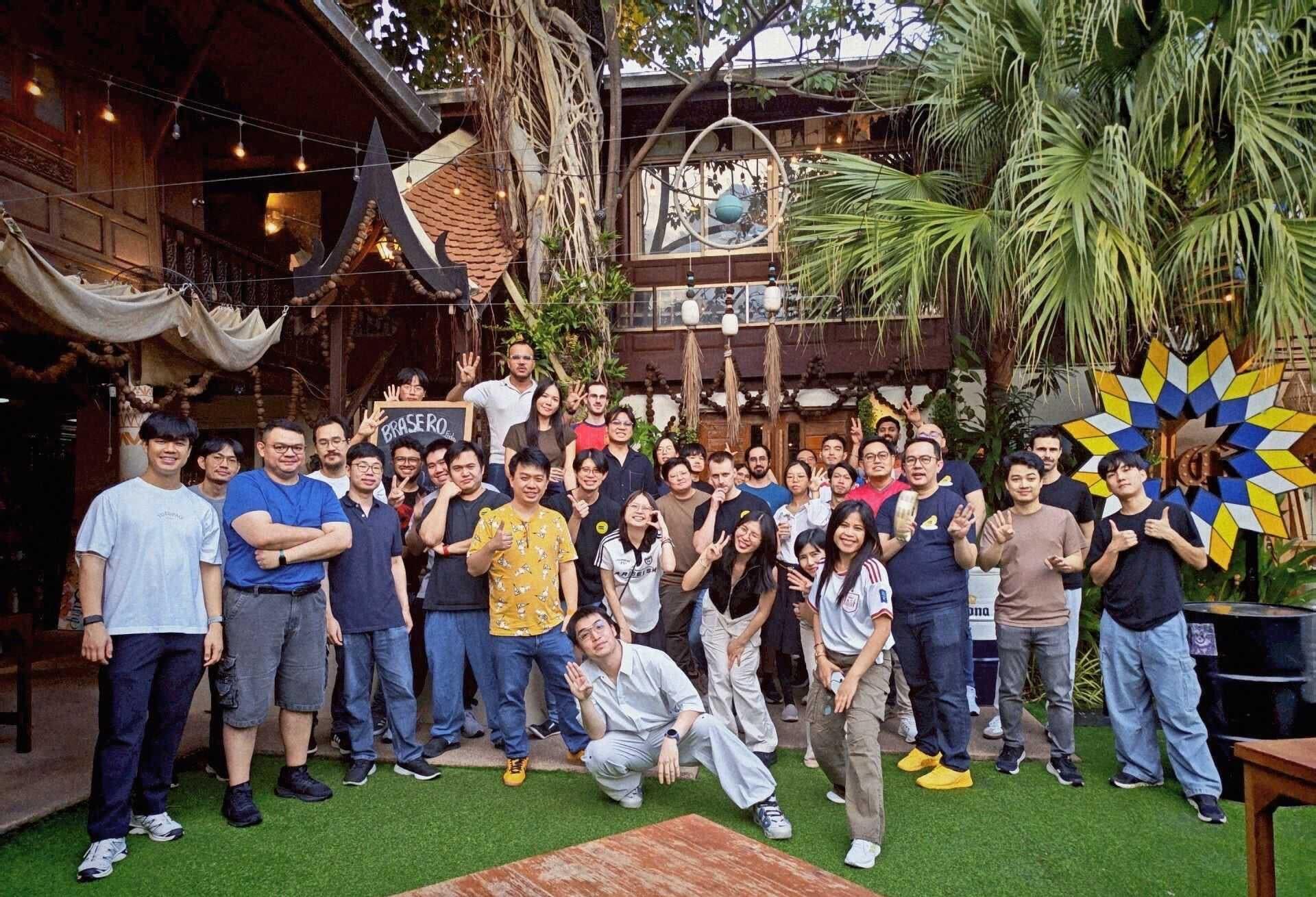 EarnIn Bangkok team gathered for a group photo in a garden courtyard