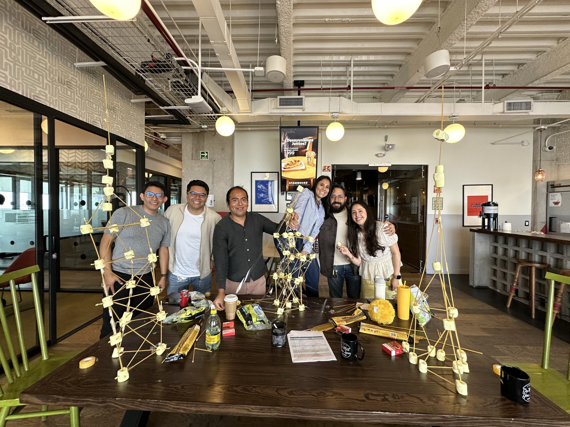EarnIn teammates in the Mexico City office with spaghetti and marshmallow towers from a team-building challenge