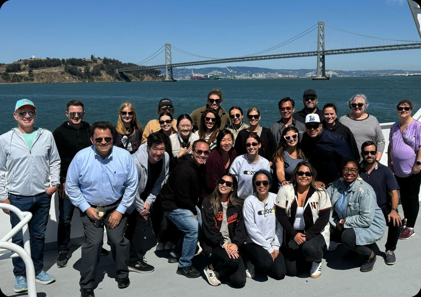 EarnIn teammates grouped together on a boat with the Bay Bridge in the background